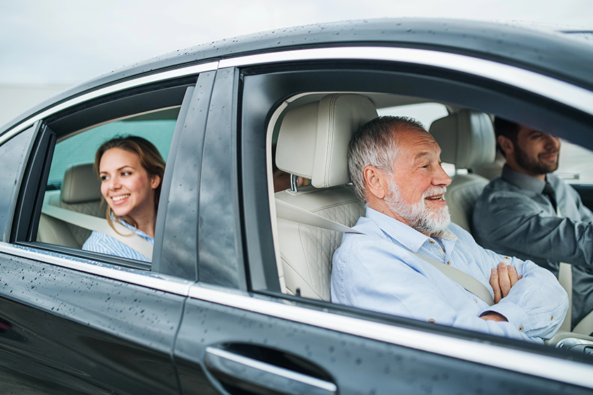 Multigeneration family sitting in car, driving and talking. 