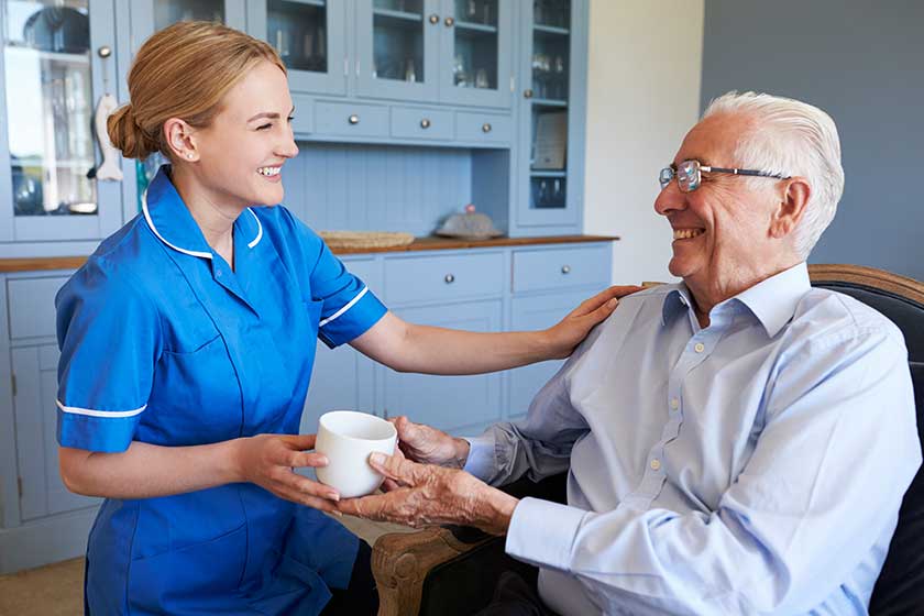 Nurse Giving Senior Man Cup Of Tea