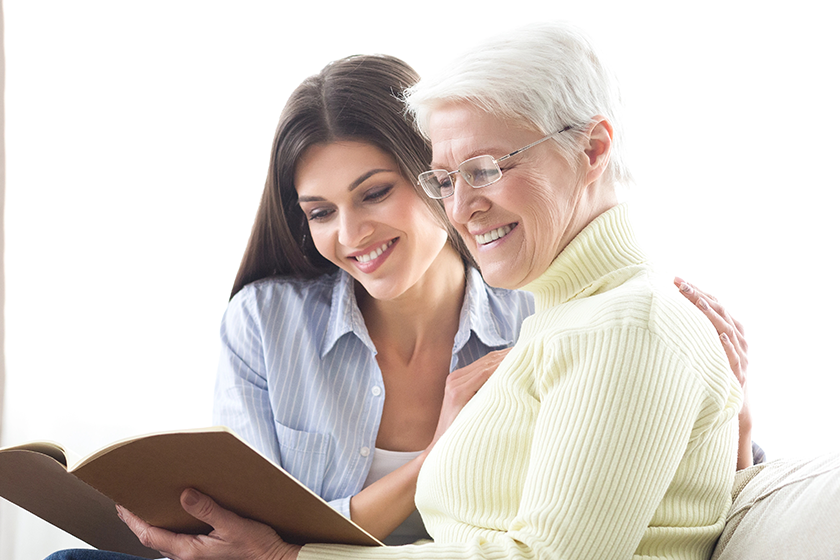 Senior mother and daughter looking catalog, searching new house 